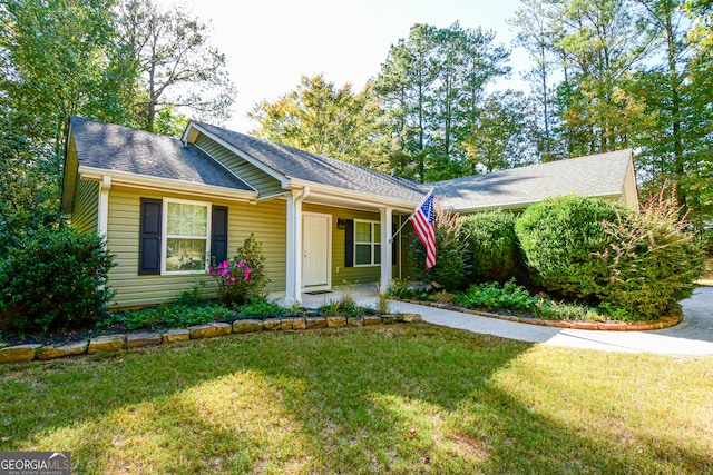 ranch-style house featuring covered porch and a front yard