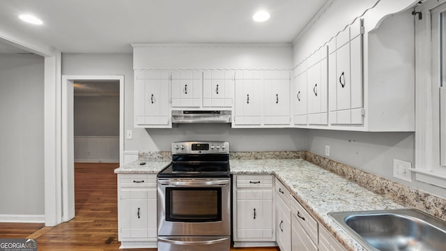 kitchen with dark hardwood / wood-style floors, electric stove, white cabinets, light stone counters, and sink