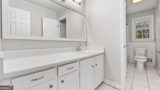 bathroom with toilet, ornamental molding, tile patterned flooring, and vanity