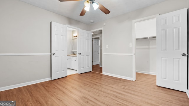 unfurnished bedroom featuring ceiling fan, a closet, light hardwood / wood-style floors, and sink