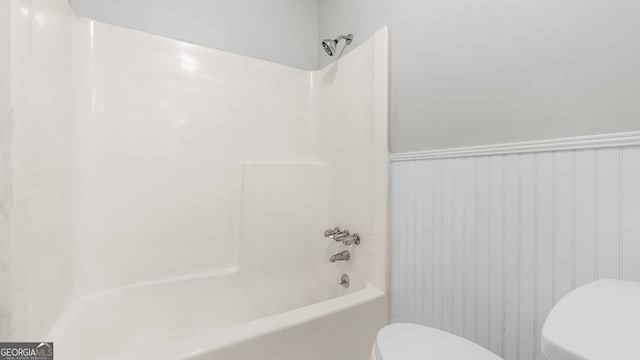 bathroom with washtub / shower combination and toilet