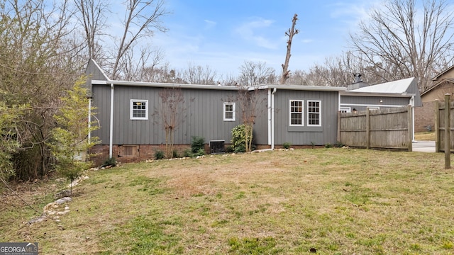 back of house with cooling unit and a yard