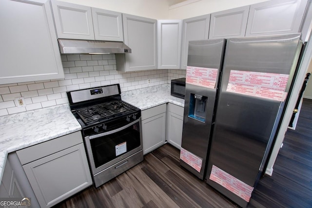 kitchen featuring decorative backsplash, gray cabinets, stainless steel appliances, and dark wood-type flooring