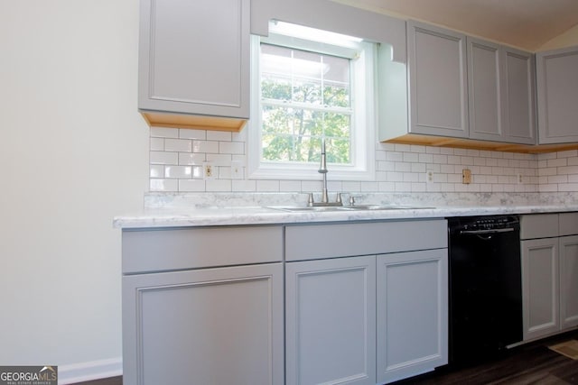 kitchen with decorative backsplash, dishwasher, light stone countertops, and sink