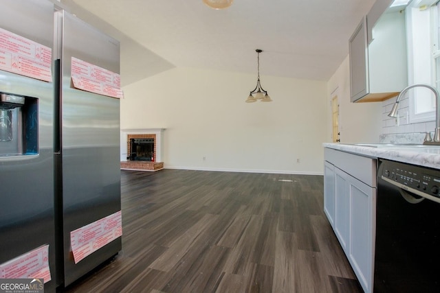 kitchen with dishwasher, sink, stainless steel refrigerator with ice dispenser, hanging light fixtures, and a fireplace