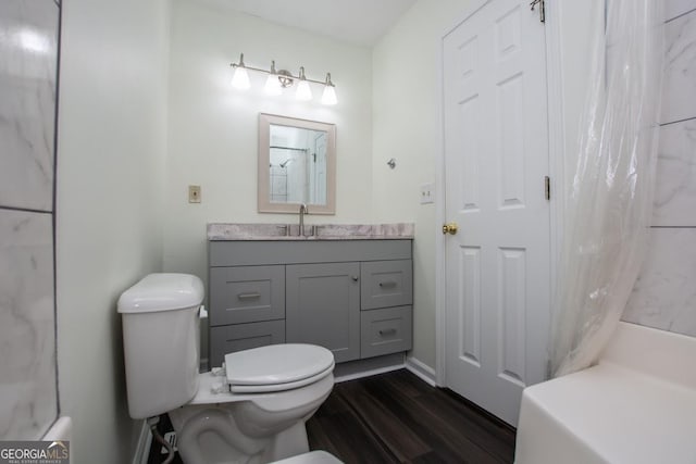 bathroom with hardwood / wood-style floors, vanity, curtained shower, and toilet