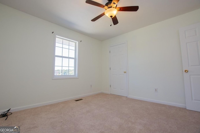 spare room featuring ceiling fan and light colored carpet