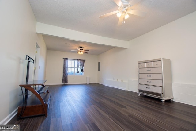 interior space featuring beamed ceiling, ceiling fan, dark hardwood / wood-style flooring, and a textured ceiling