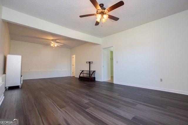 unfurnished living room with beamed ceiling, ceiling fan, dark hardwood / wood-style flooring, and a textured ceiling