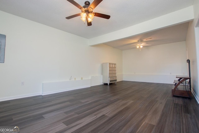 unfurnished room with ceiling fan, dark hardwood / wood-style flooring, beamed ceiling, and a textured ceiling