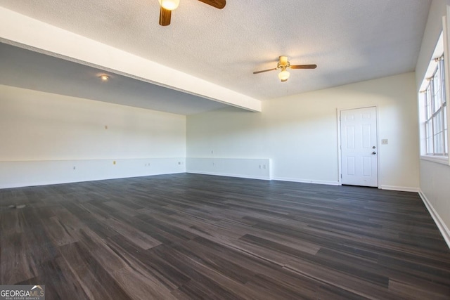 spare room featuring beam ceiling, ceiling fan, a textured ceiling, and dark hardwood / wood-style floors