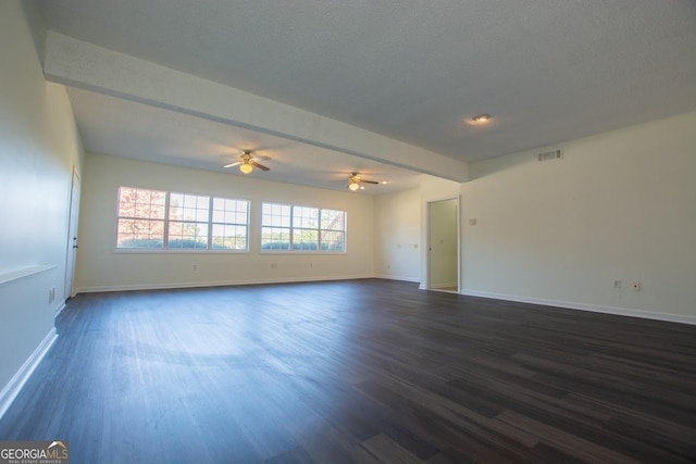 empty room featuring beamed ceiling, a textured ceiling, dark hardwood / wood-style flooring, and ceiling fan