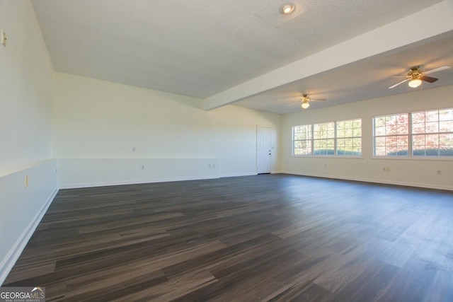 spare room with beam ceiling, a textured ceiling, ceiling fan, and dark wood-type flooring