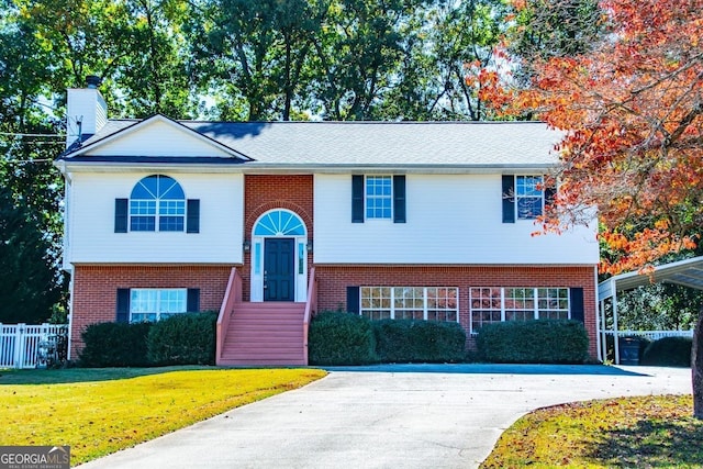 split foyer home featuring a carport and a front yard