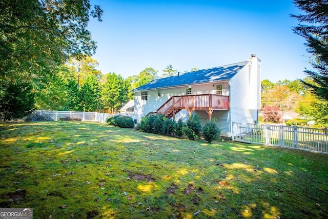 back of house featuring a deck and a lawn