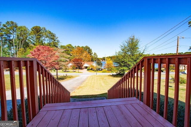 wooden deck featuring a lawn