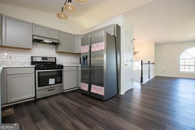 kitchen featuring dark wood-type flooring, stainless steel appliances, tasteful backsplash, a barn door, and gray cabinets