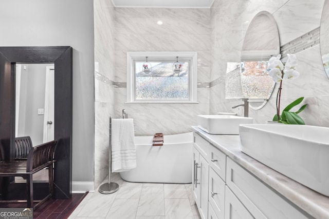 bathroom featuring a bathing tub, vanity, and tile walls