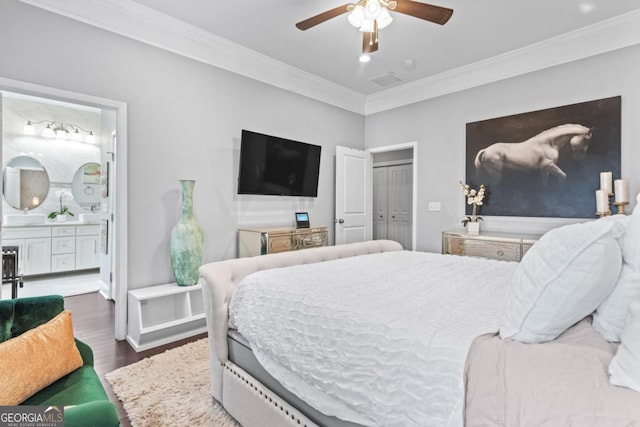 bedroom with dark wood-type flooring, crown molding, ceiling fan, connected bathroom, and a closet