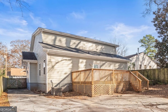 back of house with central AC unit and a deck