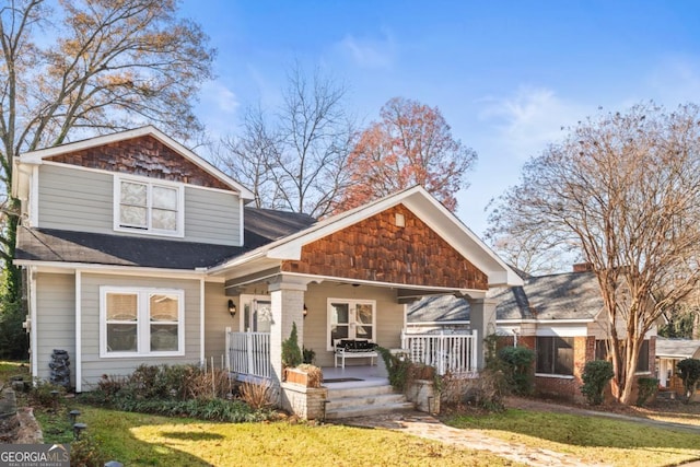 view of front of home with covered porch and a front lawn