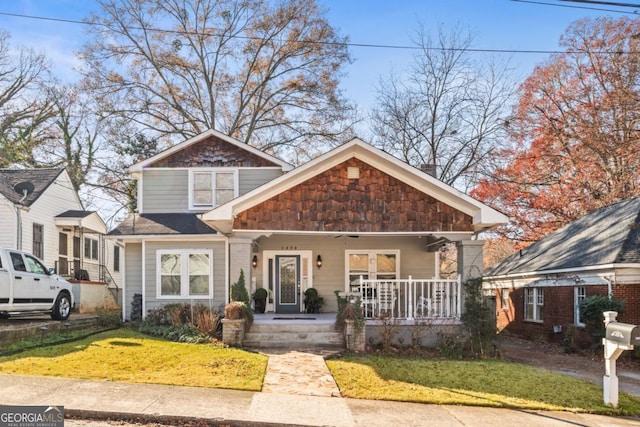 view of front of home with covered porch and a front yard