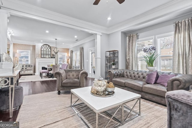 living room with light hardwood / wood-style flooring, ceiling fan, and ornamental molding