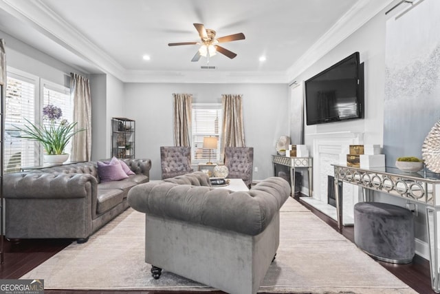 living room featuring hardwood / wood-style floors, ceiling fan, and crown molding