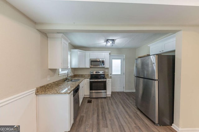 kitchen featuring light stone countertops, white cabinetry, sink, and stainless steel appliances