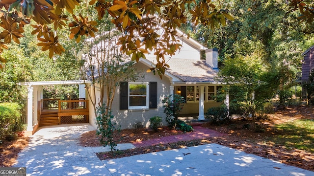 view of front of home featuring a chimney, a deck, and brick siding