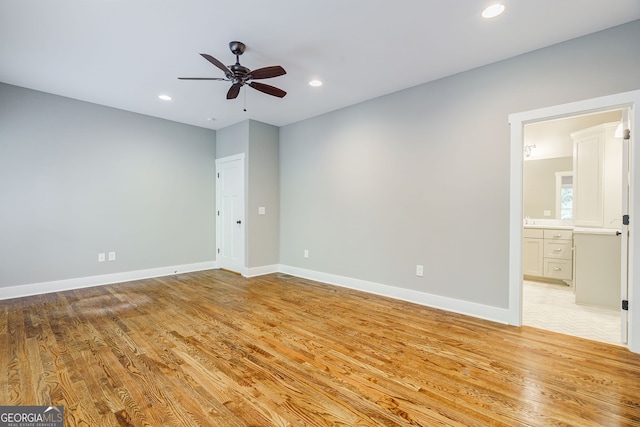 unfurnished bedroom featuring baseboards, light wood-type flooring, connected bathroom, and recessed lighting