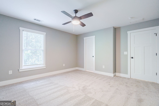 carpeted spare room with ceiling fan