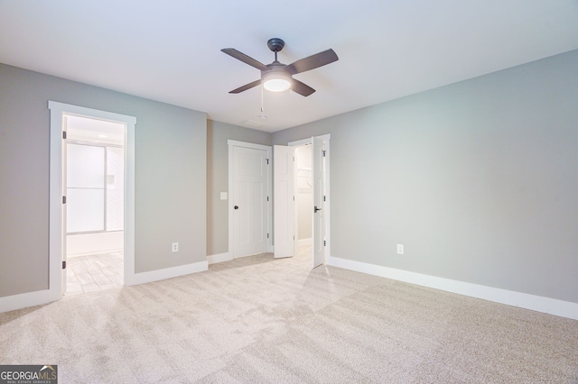 unfurnished bedroom with light carpet, connected bathroom, and ceiling fan