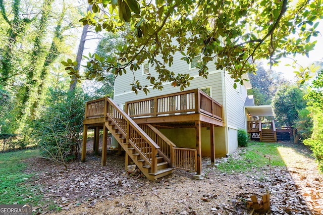 rear view of property with a wooden deck and stairway