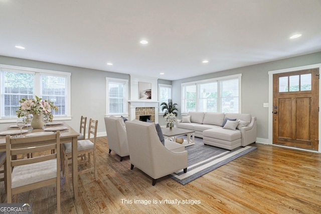 living room featuring light wood-style flooring, baseboards, plenty of natural light, and recessed lighting