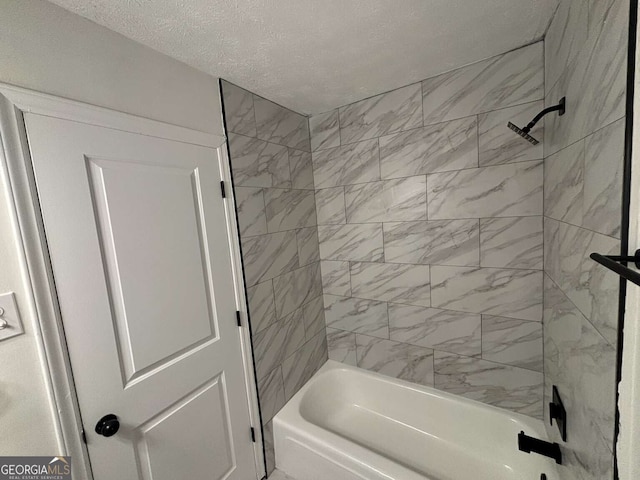 bathroom featuring a textured ceiling and tiled shower / bath combo