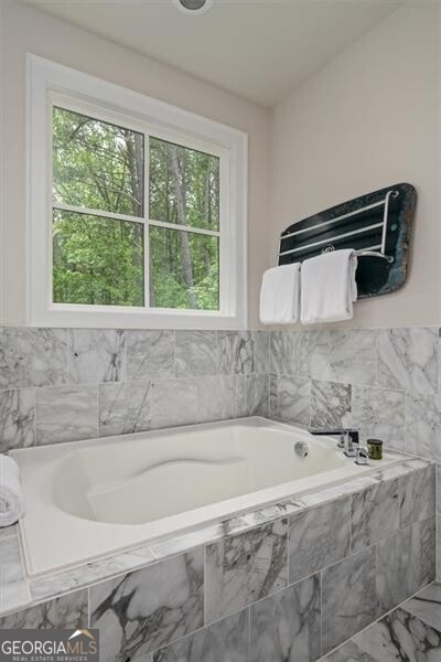 bathroom featuring tiled tub