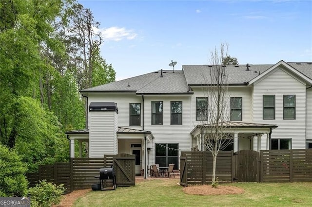 rear view of house featuring a yard