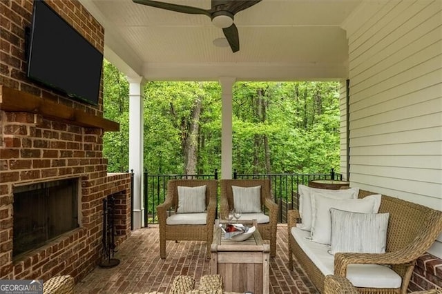 view of patio with ceiling fan and an outdoor living space with a fireplace