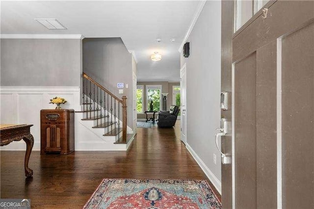 foyer with dark hardwood / wood-style floors and crown molding