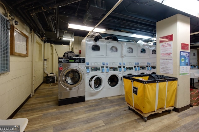 laundry area with hardwood / wood-style floors, washing machine and dryer, and stacked washer / dryer