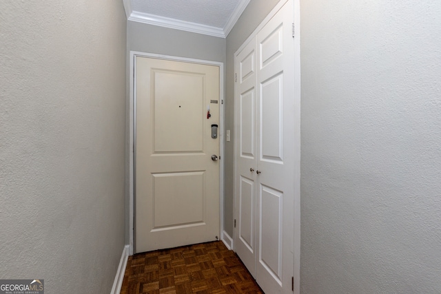 doorway to outside featuring dark parquet flooring, a textured ceiling, and ornamental molding