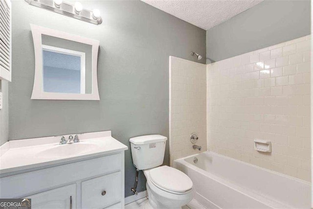 full bathroom featuring tiled shower / bath combo, toilet, a textured ceiling, and vanity