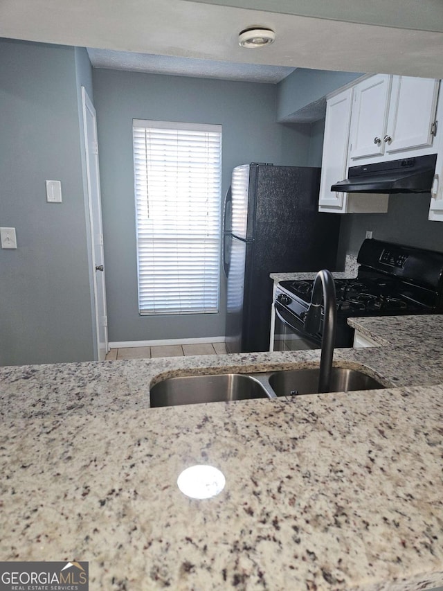 kitchen with light stone counters, white cabinetry, and black appliances