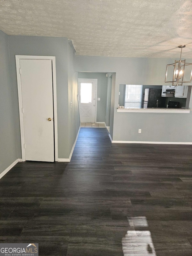 interior space with a notable chandelier, dark hardwood / wood-style floors, and a textured ceiling