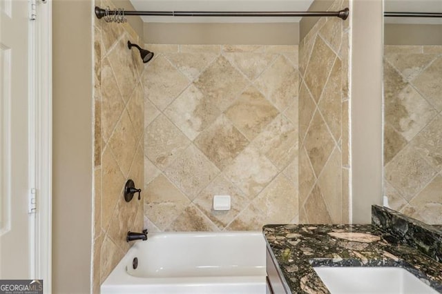 bathroom featuring tiled shower / bath combo and vanity