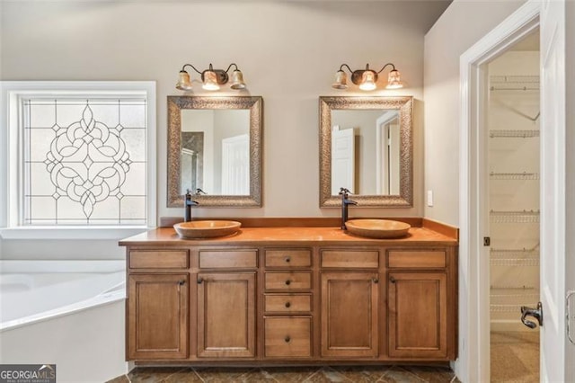 bathroom with a washtub and vanity