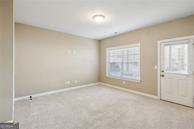 unfurnished room featuring light colored carpet and a wealth of natural light