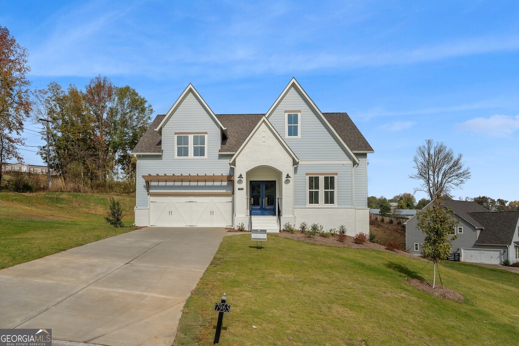 view of front of home featuring french doors, a front lawn, and a garage