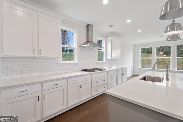 kitchen featuring white cabinetry, sink, wall chimney exhaust hood, crown molding, and stainless steel gas stovetop